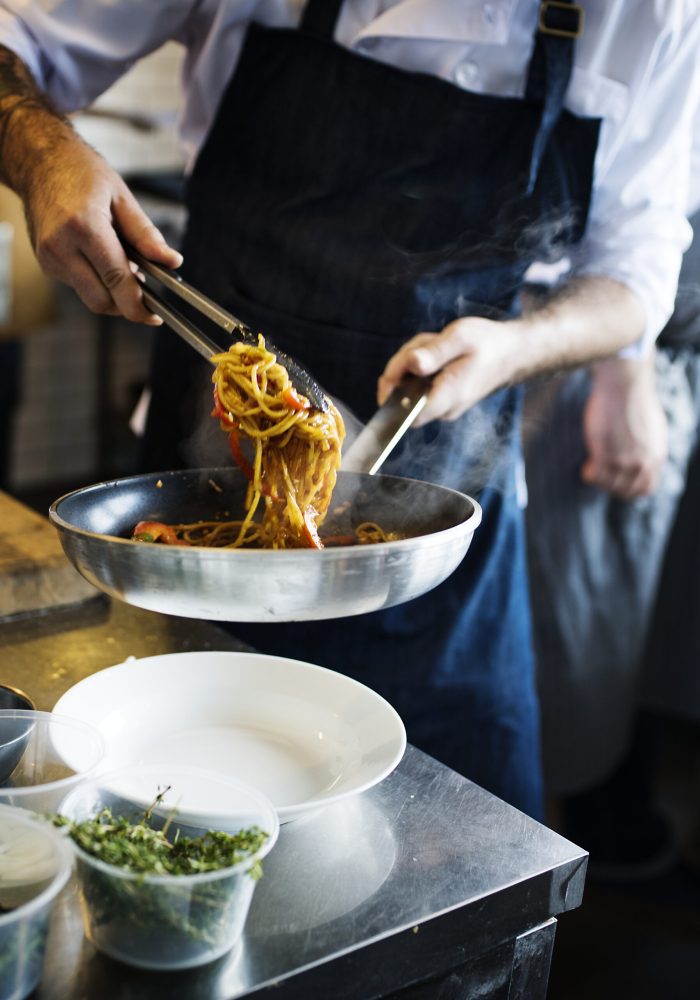 Chef cooking spaghetti in the kitchen